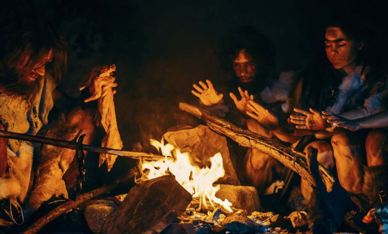 Neanderthal or Homo Sapiens Family Cooking Animal Meat over Bonfire and then Eating it. Tribe of Prehistoric Hunter-Gatherers Wearing Animal Skins Eating in a Dark Scary Cave at Night; Shutterstock ID 1595983549; purchase_order: -; job: -; client: -; other: -